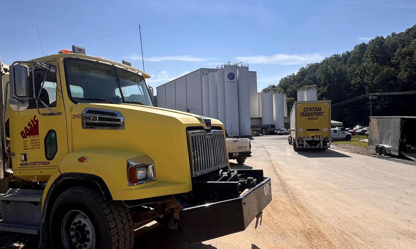 Ready-mix truck and freight staged at an operating plant
